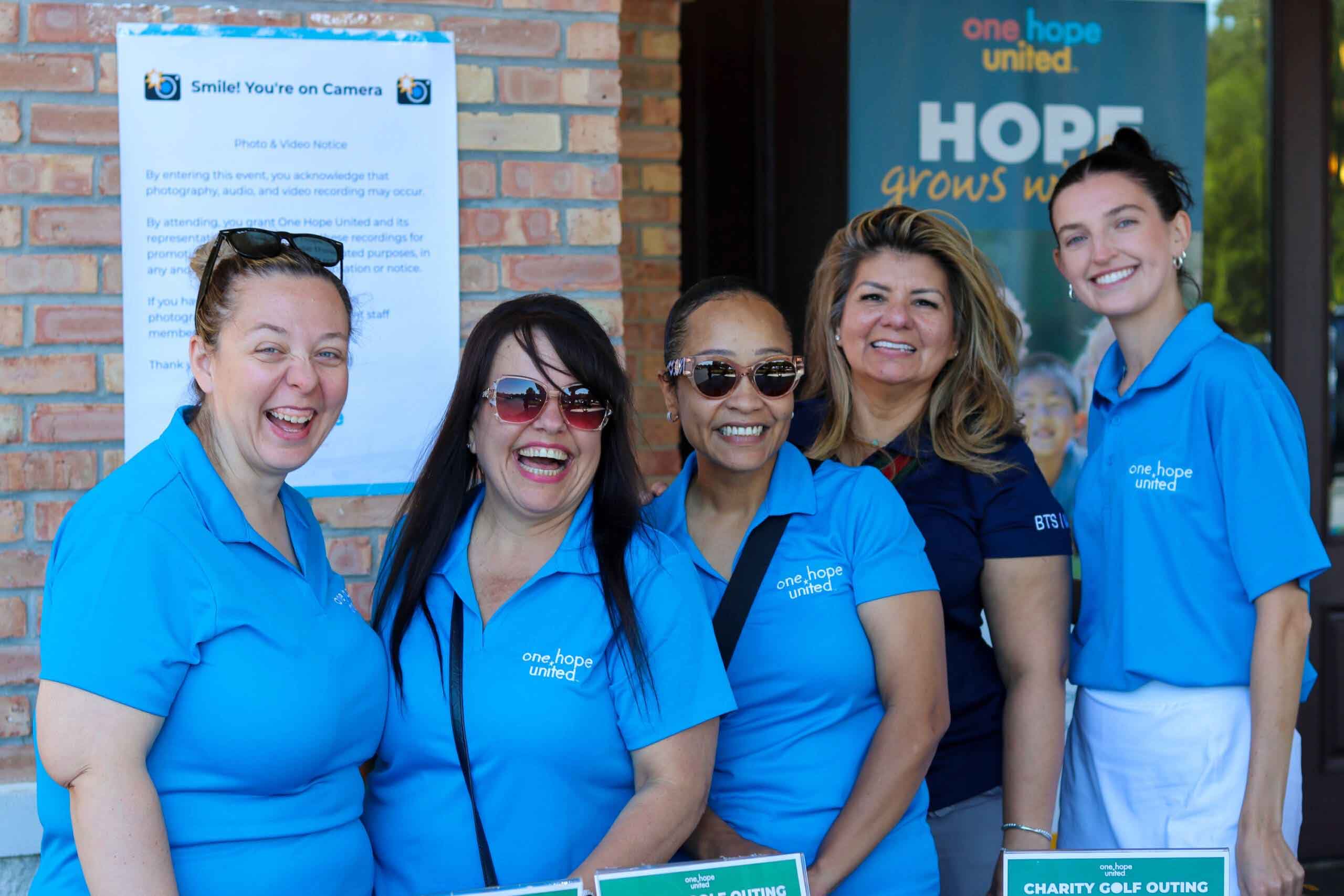 A group of volunteers smiling at One Hope United's Charity Golf Outing.