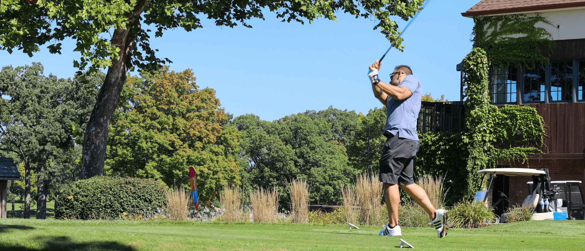 A golfer swinging his golf club at One Hope United's Charity Golf Outing.