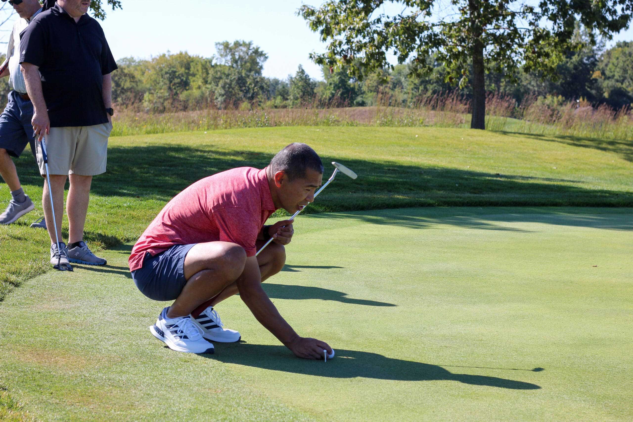 A golfer studies his putt at One Hope United's Charity Golf Outing.