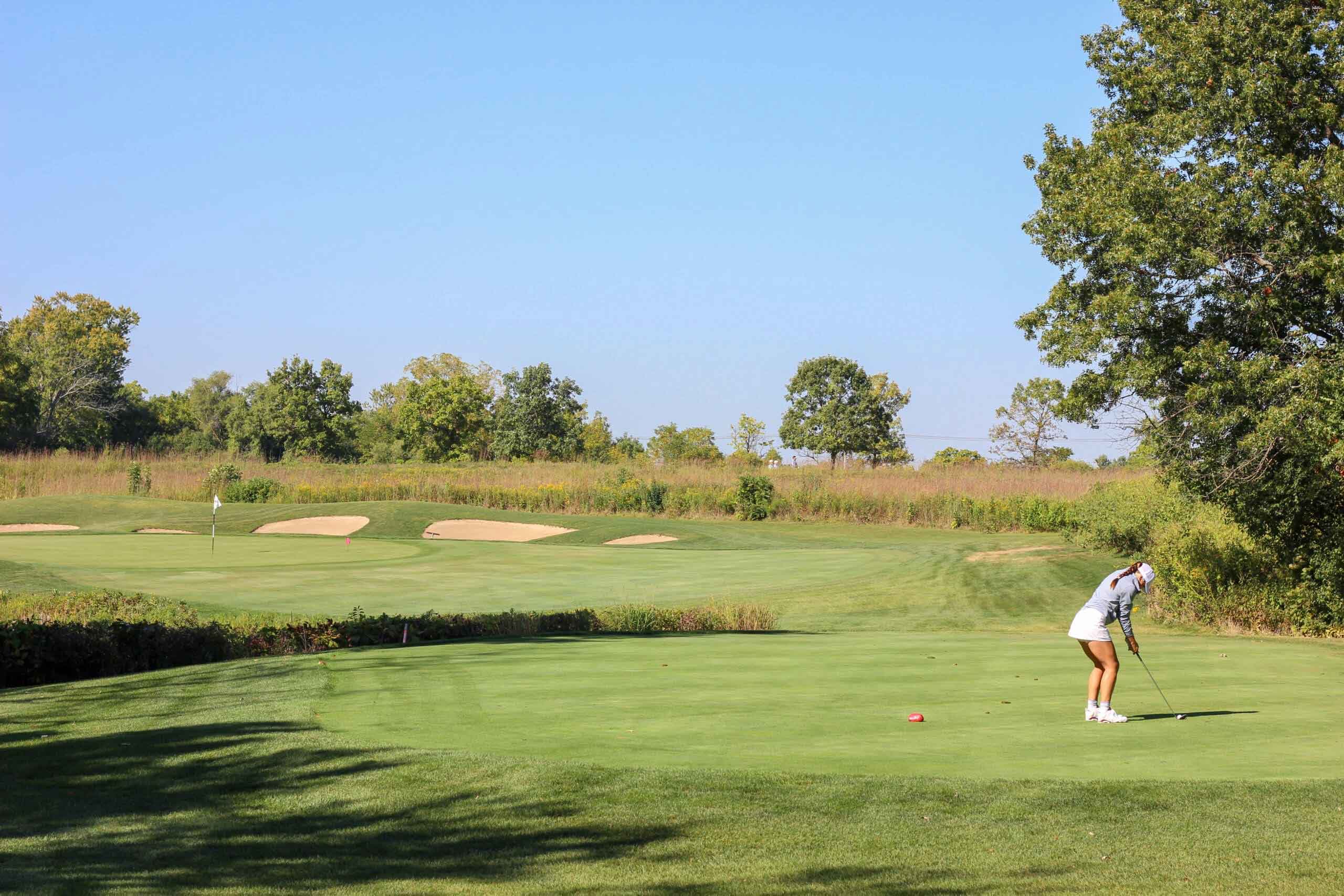 A golfer sets up her shot on the green at One Hope United's Charity Golf Outing.