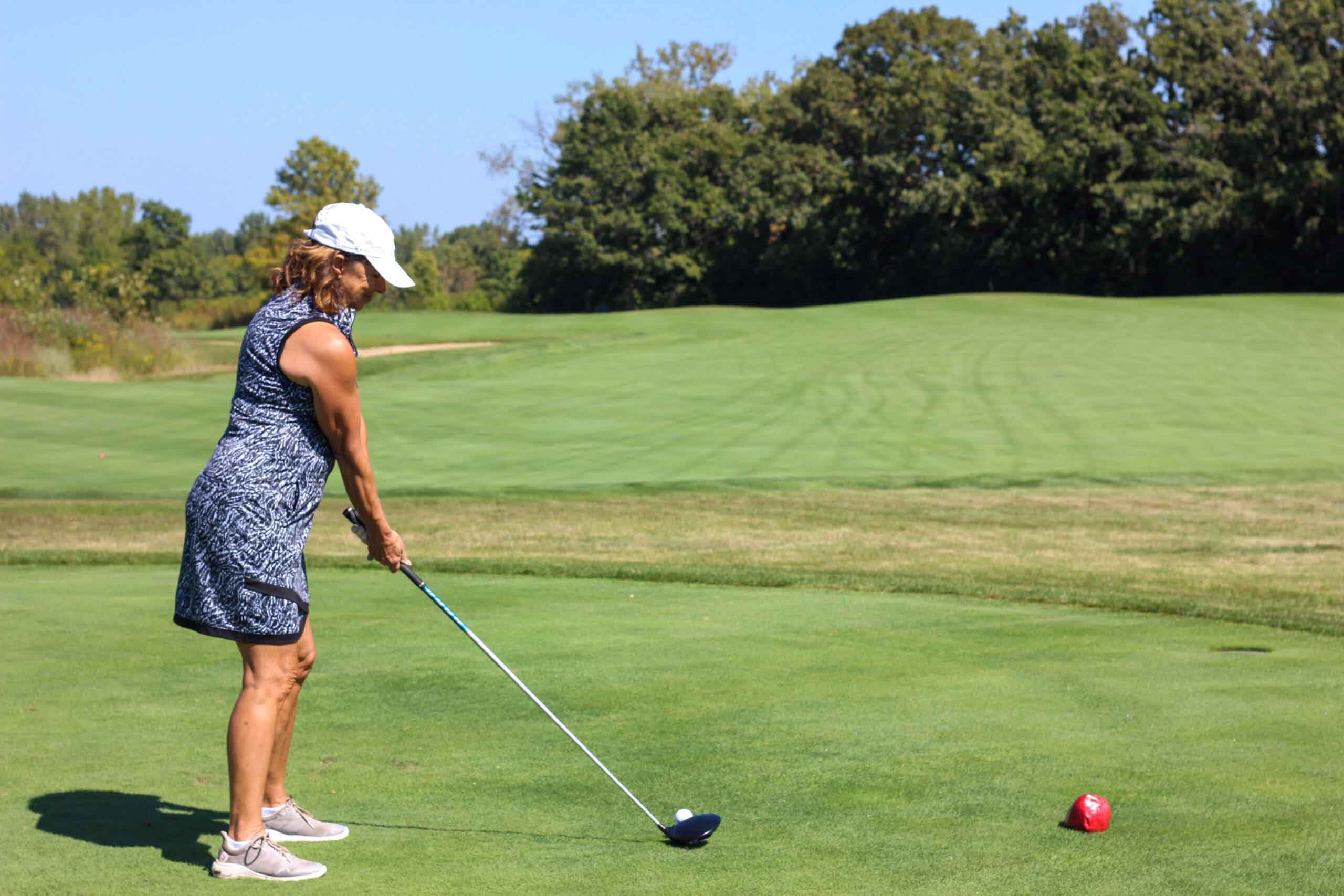 A golfer sets up her shot on the green at One Hope United's Charity Golf Outing.